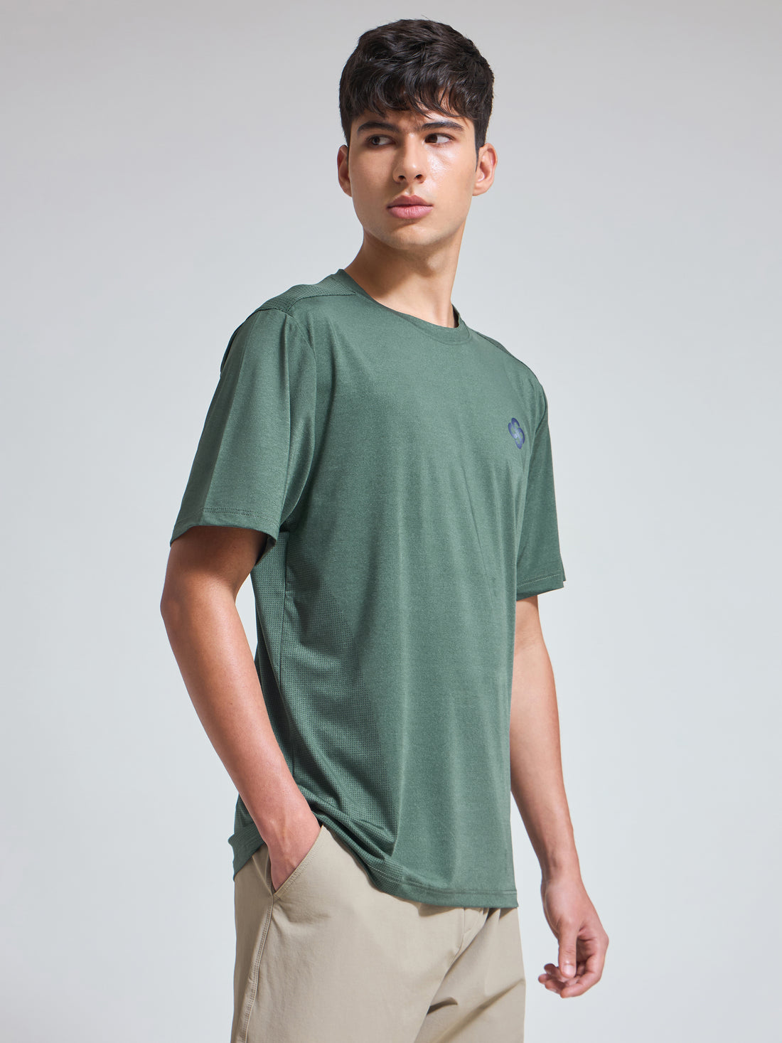 Man wearing Infinito’s dark green moisture-wicking performance tee, crafted for stretch, breathability, and all-day athleisure comfort