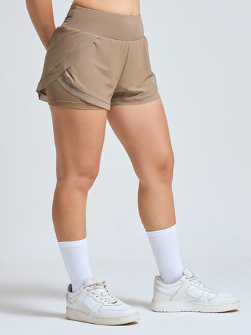 Woman wearing Infinito’s CoolShield UV Shorts in mint green, designed for sun protection, airflow, and high-performance comfort in warm weather
