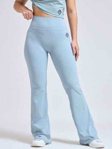 Woman wearing Infinito’s FlareFit High-Waisted Pants in sky blue, featuring a flared silhouette and supportive waistband for sculpted movement