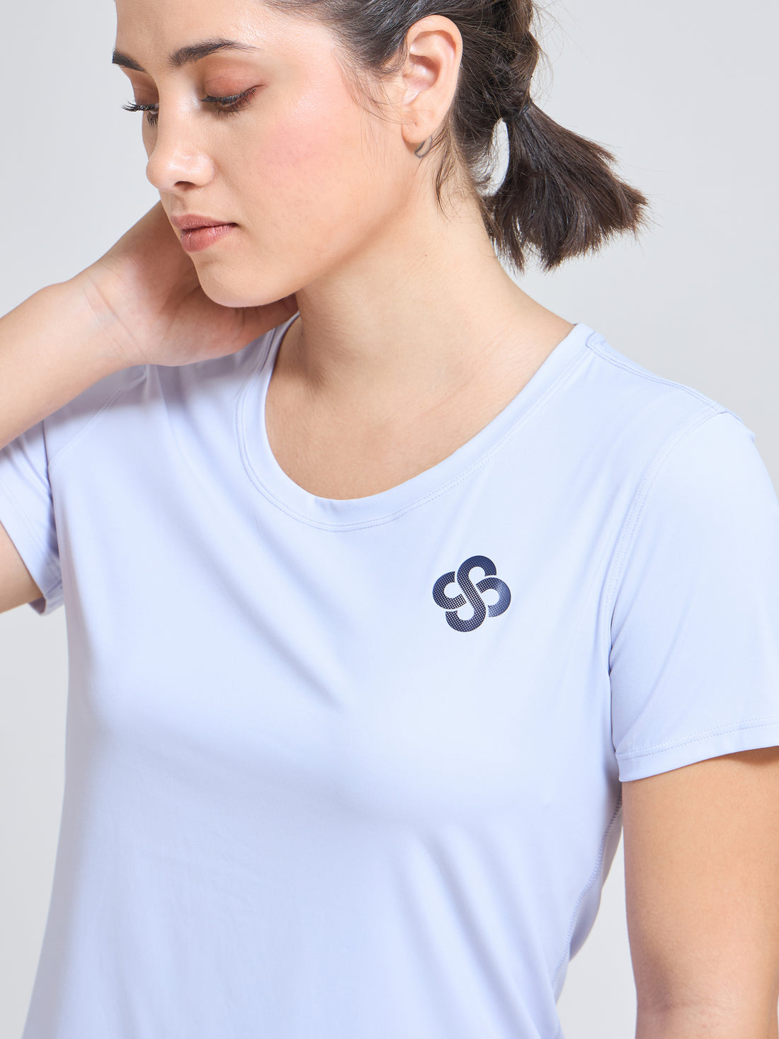 Woman wearing Infinito’s SleekTee, a lightweight, sweat-wicking workout top designed for flexibility, breathability, and all-day active comfort