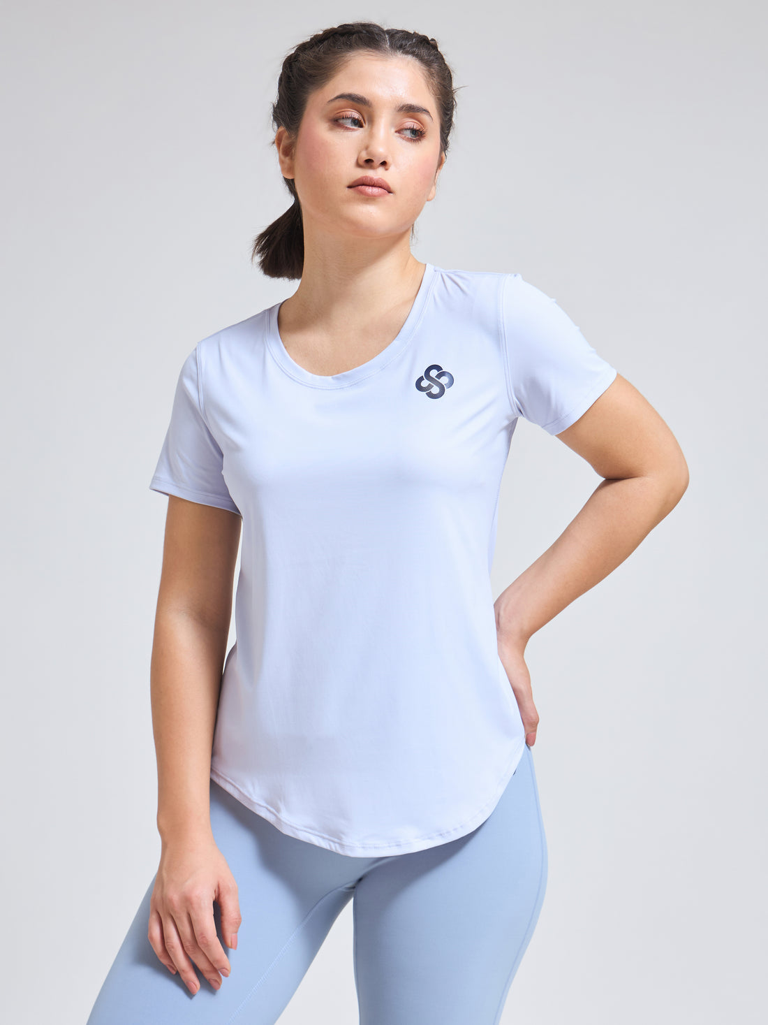 Woman wearing Infinito’s SleekTee, a lightweight, sweat-wicking workout top designed for flexibility, breathability, and all-day active comfort