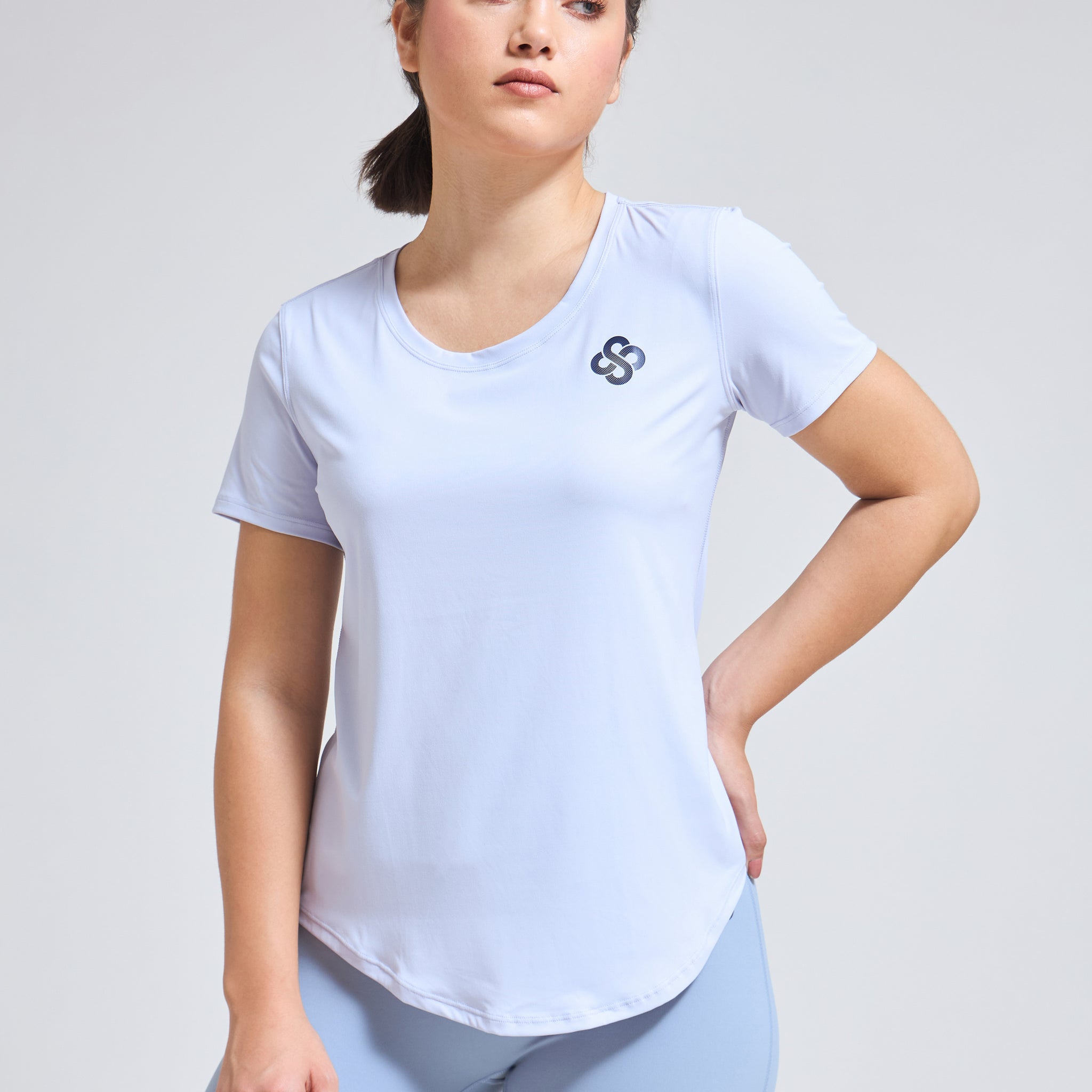 Woman wearing Infinito’s SleekTee, a lightweight, sweat-wicking workout top designed for flexibility, breathability, and all-day active comfort