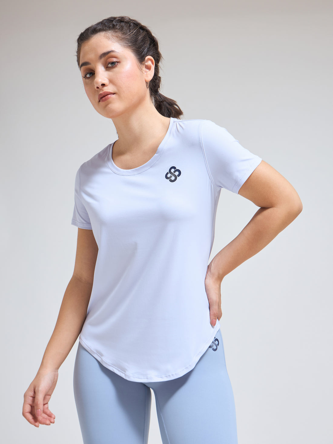 Woman wearing Infinito’s SleekTee, a lightweight, sweat-wicking workout top designed for flexibility, breathability, and all-day active comfort
