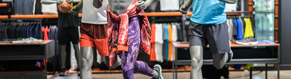 Mannequins dressed in colorful activewear and athletic gear inside a modern sports apparel store, showcasing leggings, shorts, and jackets