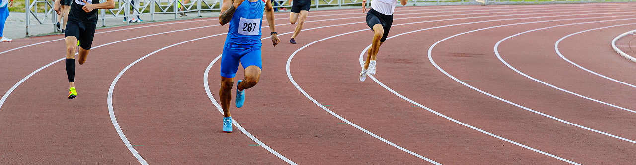 Athletes sprinting on a track, runner in blue (287) leading the race